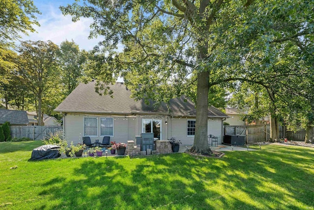 rear view of house with a patio and a lawn