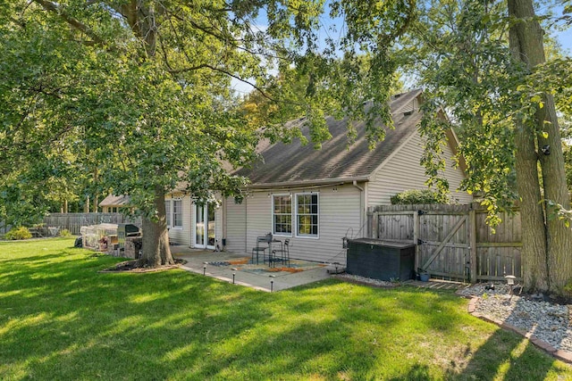 back of property with a patio area and a yard