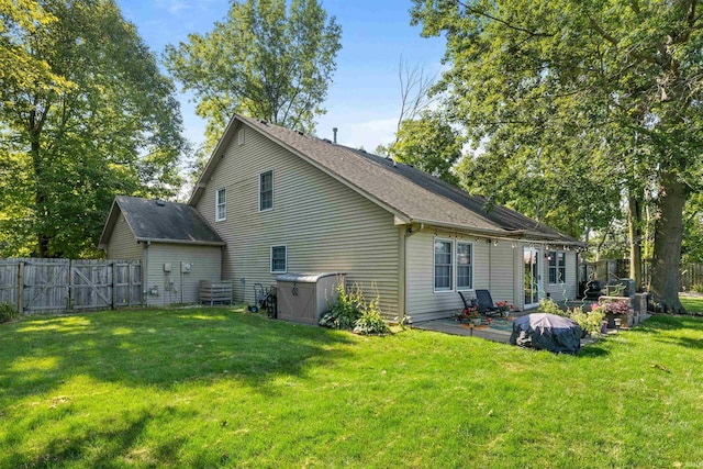 back of house featuring a patio area and a yard