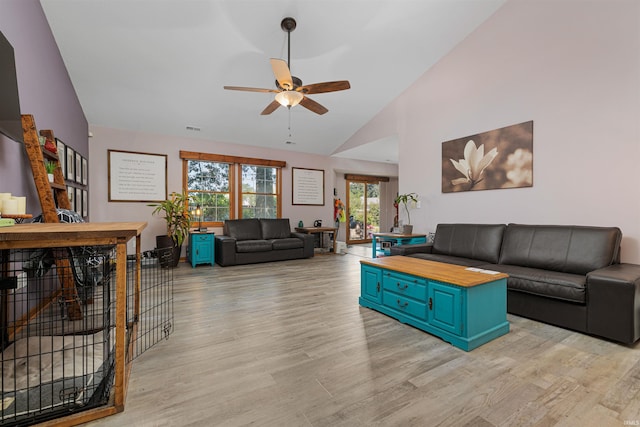 living room with ceiling fan, light hardwood / wood-style floors, and lofted ceiling