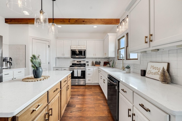 kitchen with a center island, tasteful backsplash, beamed ceiling, white cabinets, and appliances with stainless steel finishes