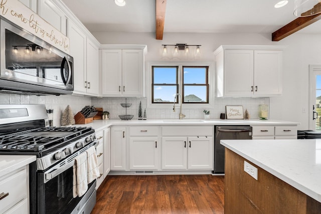 kitchen featuring dark hardwood / wood-style flooring, stainless steel appliances, sink, beam ceiling, and white cabinets