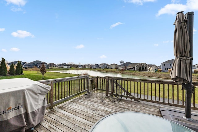 wooden terrace with a yard, a water view, and grilling area