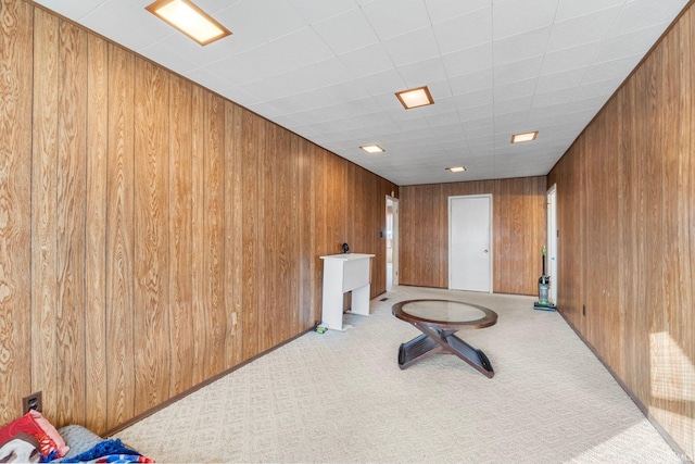 interior space with light carpet and wooden walls