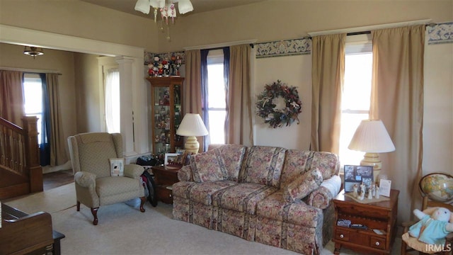 living room with ceiling fan, light colored carpet, ornate columns, and a wealth of natural light