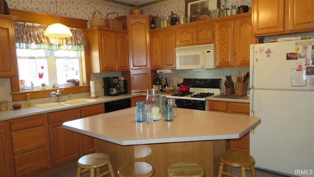 kitchen featuring a center island, sink, white appliances, and a breakfast bar area