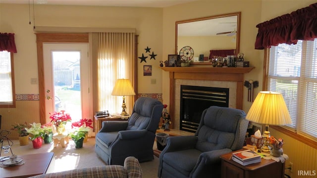 living area featuring a wealth of natural light, ceiling fan, and a fireplace