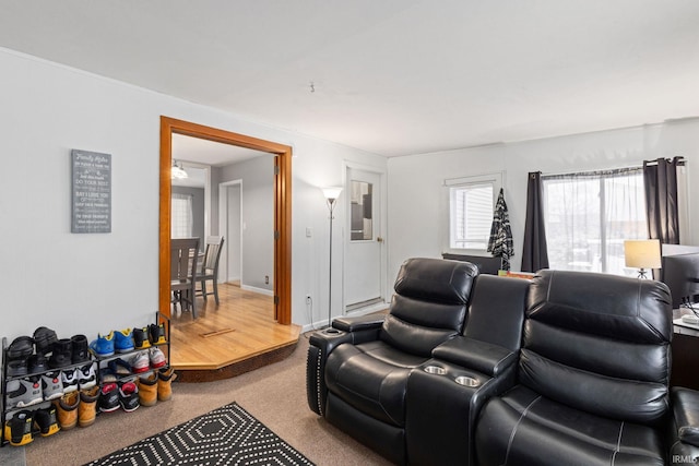 carpeted home theater featuring an inviting chandelier