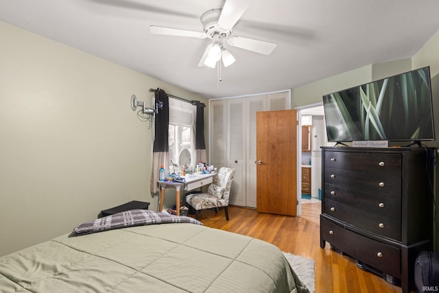 bedroom with a closet, light hardwood / wood-style flooring, and ceiling fan