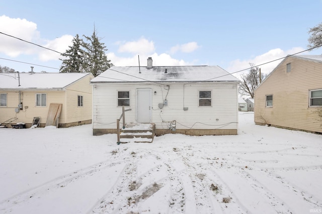 view of snow covered rear of property