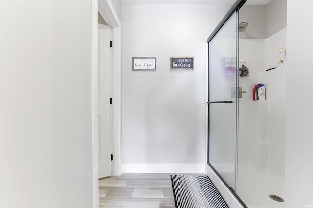 bathroom with hardwood / wood-style flooring and walk in shower