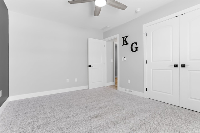 unfurnished bedroom with a closet, ceiling fan, and light colored carpet