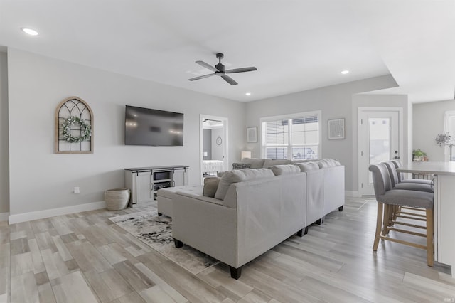 living room featuring light hardwood / wood-style floors and ceiling fan