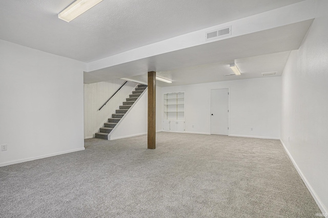 basement with carpet flooring and a textured ceiling