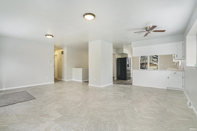 unfurnished living room with ceiling fan and sink