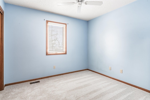 carpeted spare room with a textured ceiling and ceiling fan