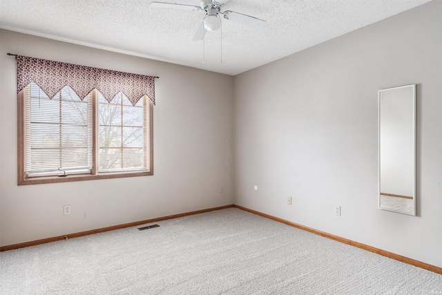 empty room featuring ceiling fan, carpet, and a textured ceiling