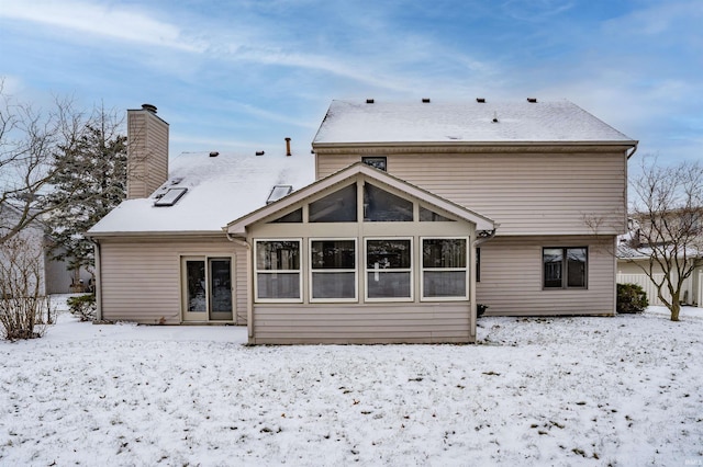 snow covered house with a sunroom