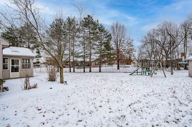 yard layered in snow with a playground