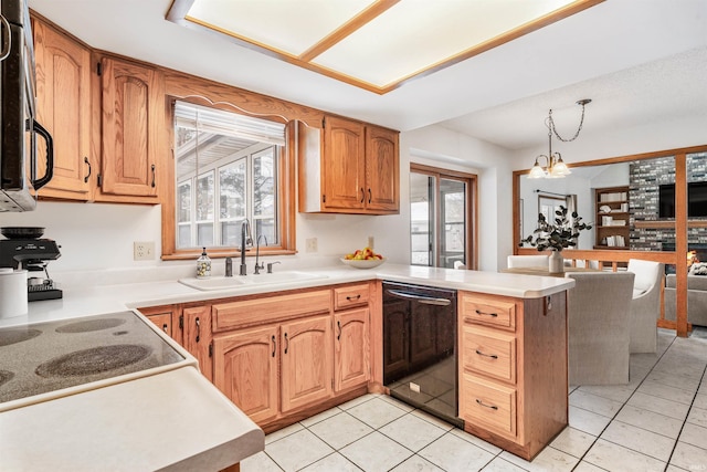 kitchen featuring kitchen peninsula, sink, pendant lighting, a notable chandelier, and dishwasher