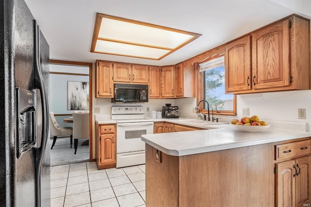 kitchen featuring kitchen peninsula, light tile patterned floors, sink, and black appliances