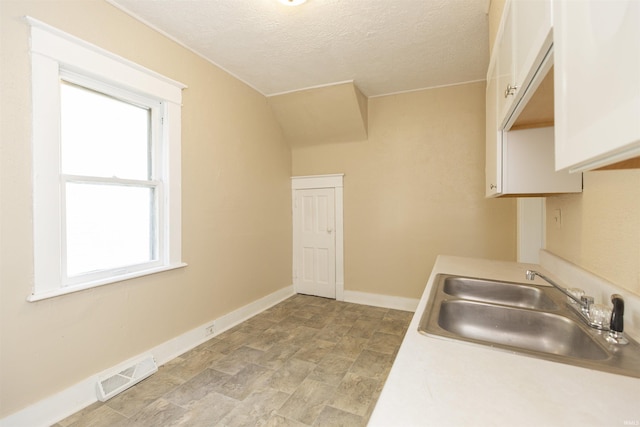 kitchen featuring a textured ceiling and sink