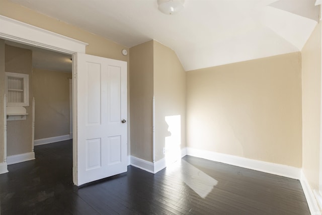 bonus room with vaulted ceiling and dark wood-type flooring