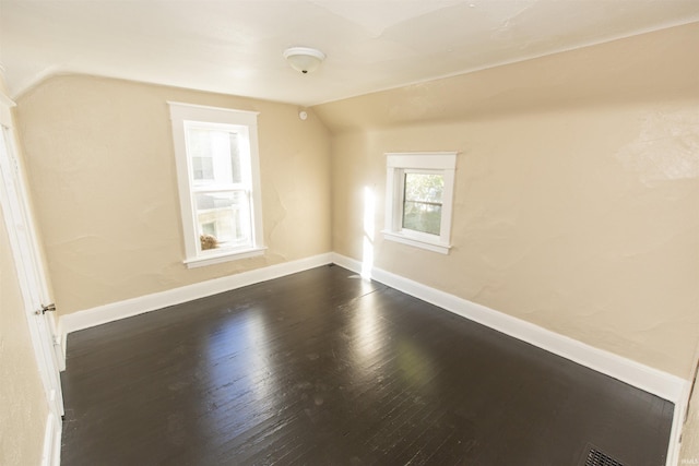 additional living space featuring dark hardwood / wood-style floors and vaulted ceiling