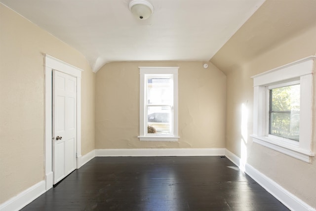 bonus room with dark hardwood / wood-style flooring and vaulted ceiling