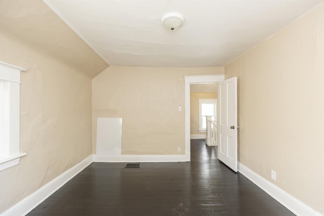 additional living space featuring dark hardwood / wood-style flooring and lofted ceiling