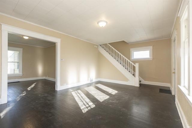 unfurnished living room with crown molding and dark wood-type flooring