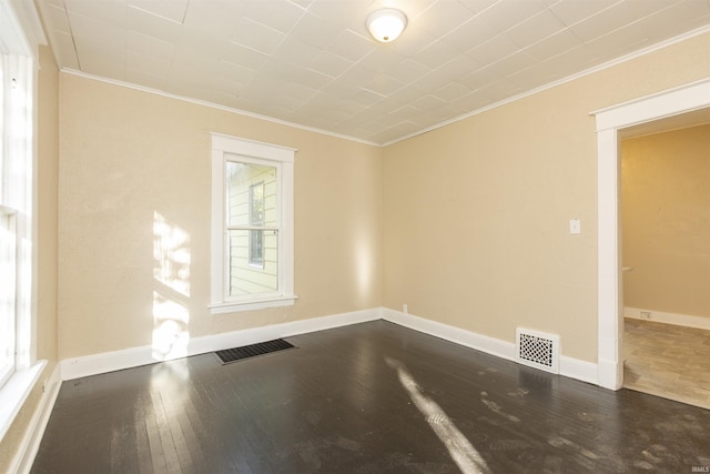 spare room featuring a wealth of natural light, ornamental molding, and hardwood / wood-style flooring