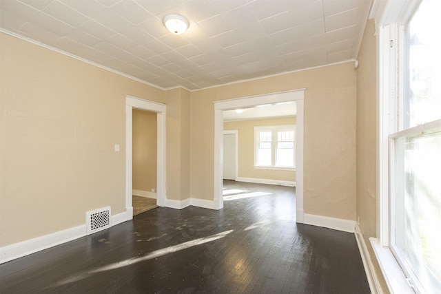 empty room with dark hardwood / wood-style floors and crown molding