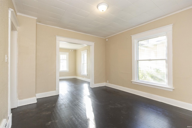 unfurnished room featuring ornamental molding and dark wood-type flooring