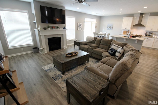 living room featuring ceiling fan, sink, and hardwood / wood-style flooring