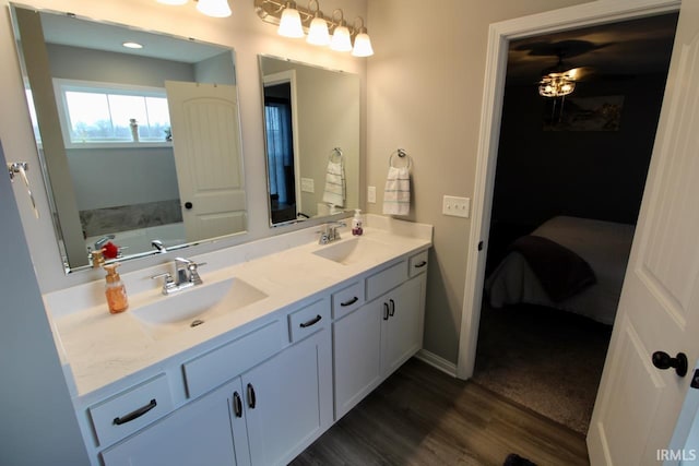 bathroom with hardwood / wood-style flooring, vanity, and a bathtub