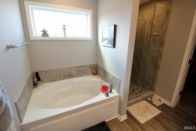 bathroom with hardwood / wood-style floors and independent shower and bath