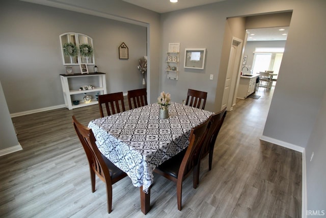 dining area with hardwood / wood-style floors and sink