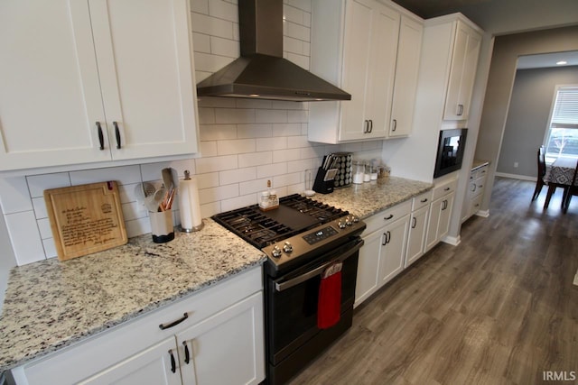 kitchen featuring decorative backsplash, white cabinetry, wall chimney exhaust hood, and black appliances