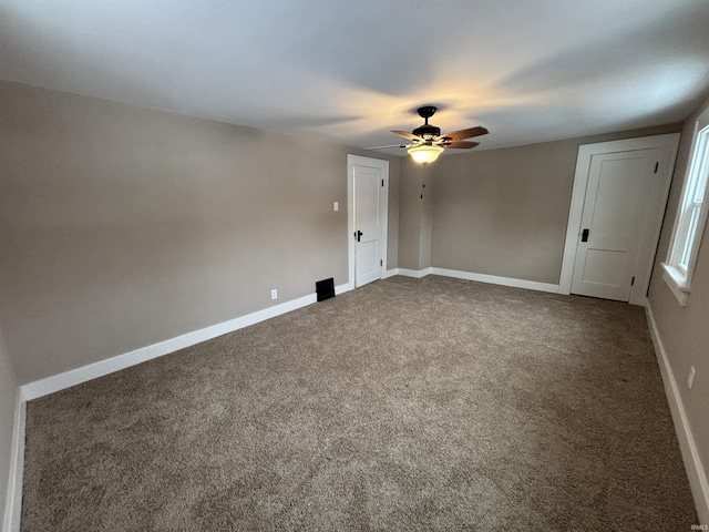 carpeted spare room featuring ceiling fan