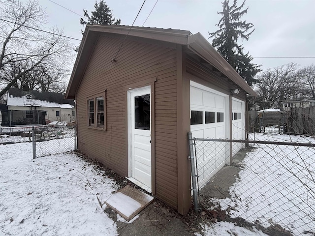 view of snow covered exterior with an outdoor structure and a garage