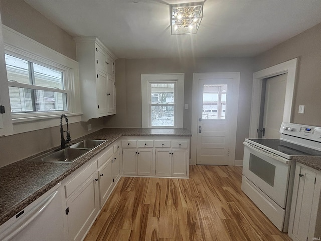 kitchen featuring white appliances, white cabinetry, a wealth of natural light, and sink