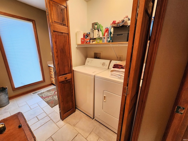 clothes washing area featuring a wealth of natural light and washing machine and clothes dryer