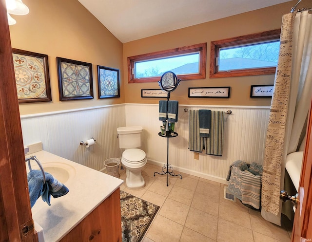 bathroom featuring tile patterned flooring, vanity, toilet, and lofted ceiling