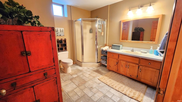 bathroom featuring vanity, toilet, and a shower with shower door