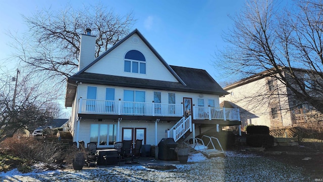 snow covered rear of property featuring a balcony