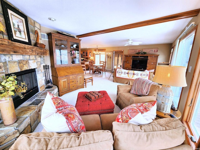 living room with beam ceiling, a fireplace, and ceiling fan with notable chandelier