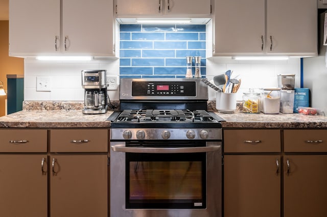 kitchen with ventilation hood, backsplash, and stainless steel range with gas stovetop