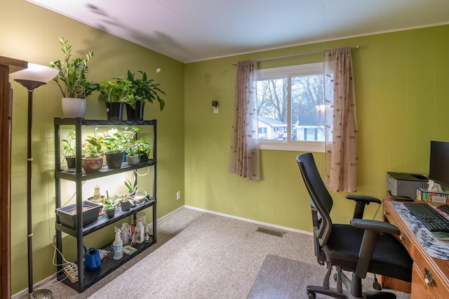 carpeted home office featuring crown molding