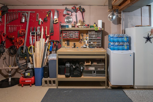 interior space featuring a workshop area, refrigerator, and white fridge